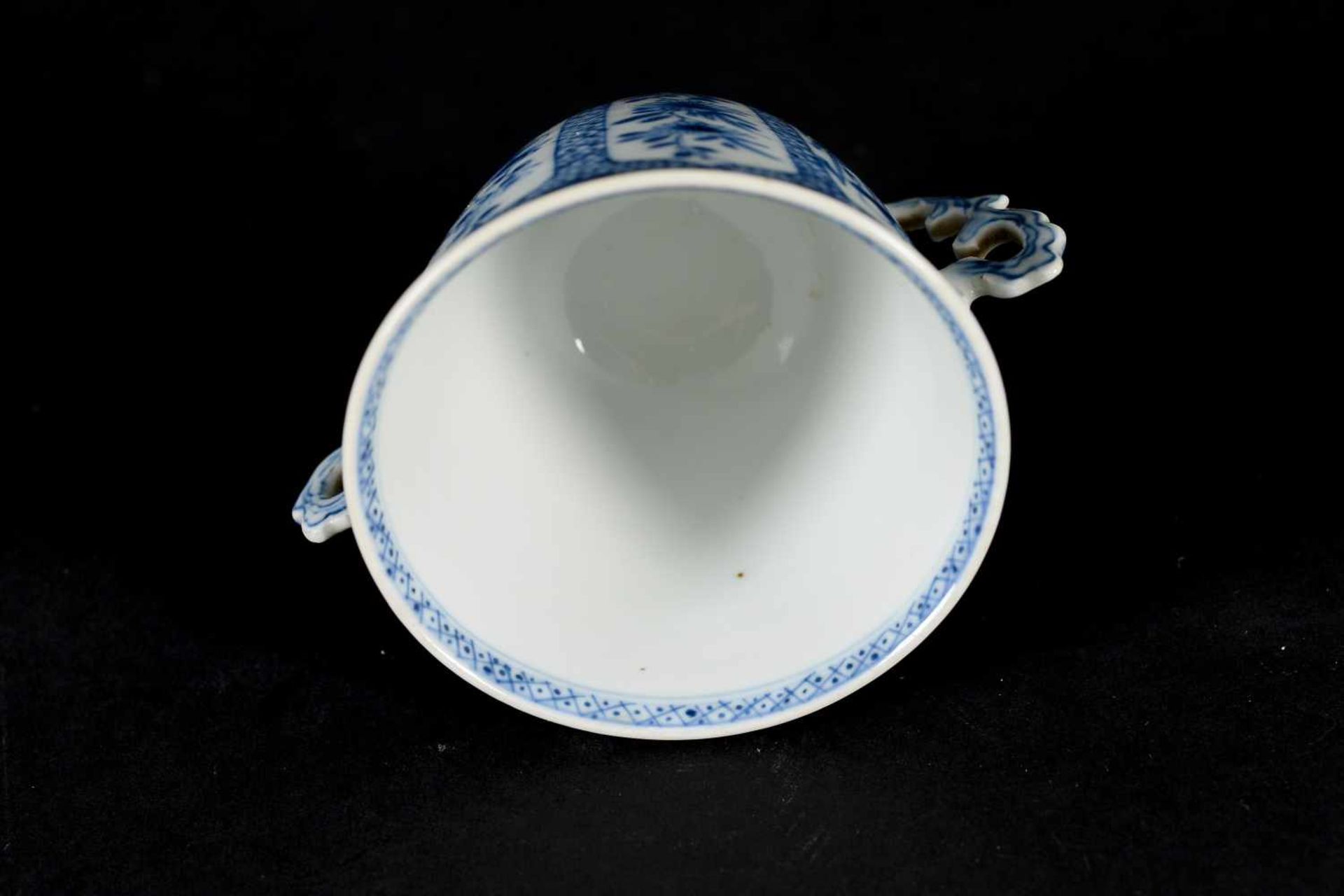 A blue and white porcelain lidded cup with two handles on a deep saucer, decorated with flowers. - Image 8 of 9
