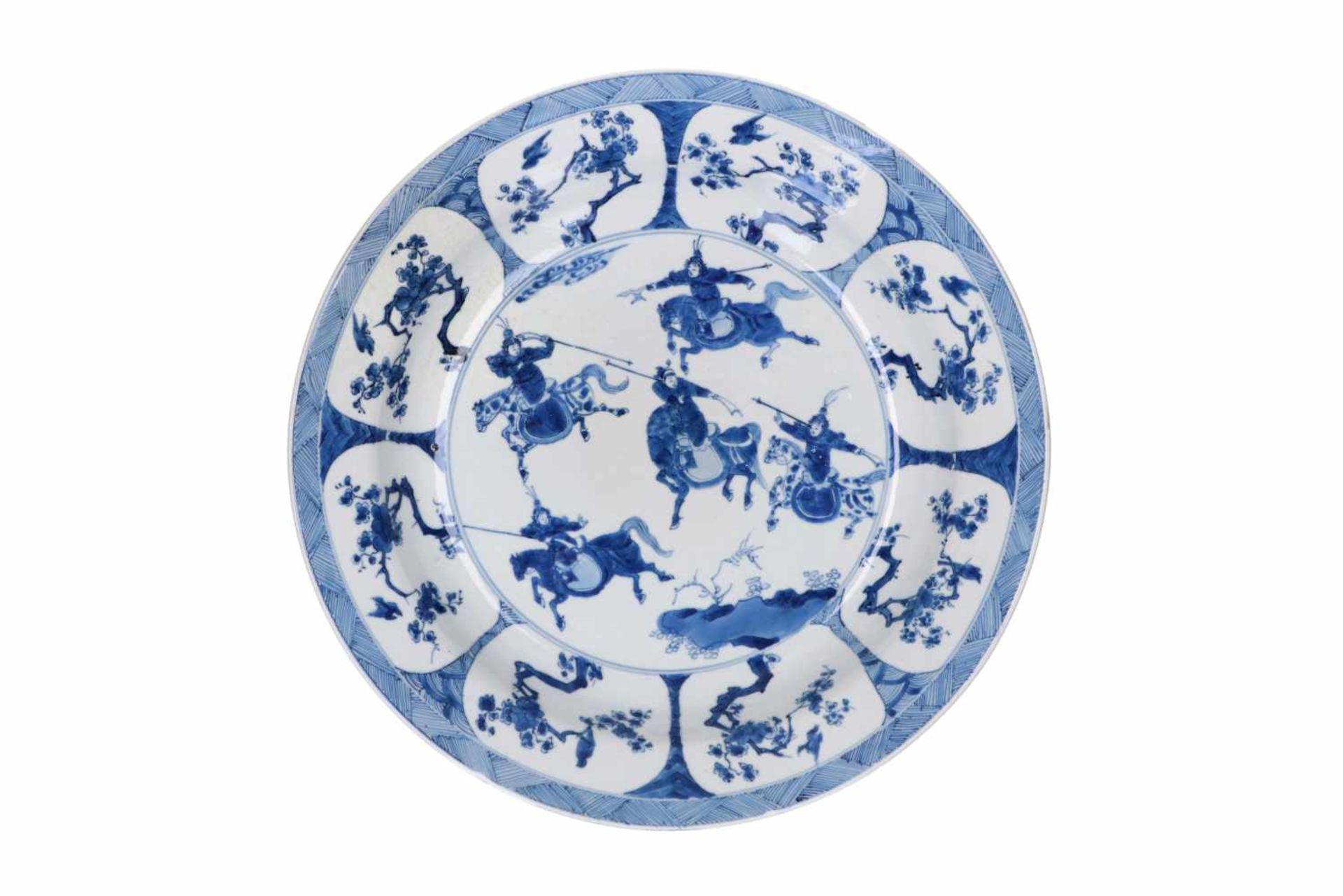 A blue and white porcelain deep charger, decorated with horsemen, flowers and birds. Marked with 6-
