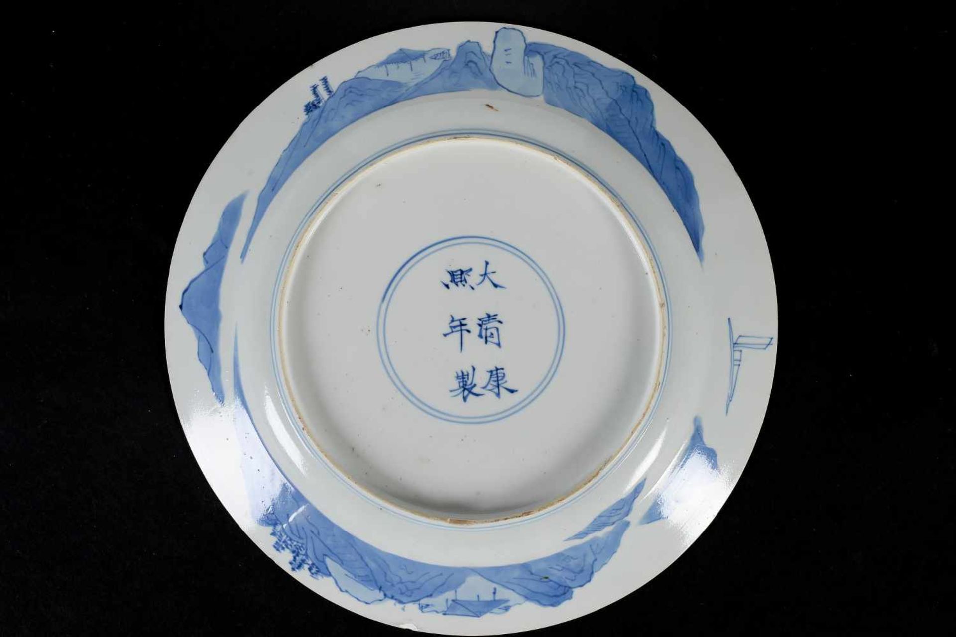 A blue and white porcelain dish, decorated with long Eliza on a bench in a garden. Marked with 6- - Image 2 of 3