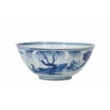 A blue and white porcelain bowl, decorated with a past-master in a mountainous river landscape.