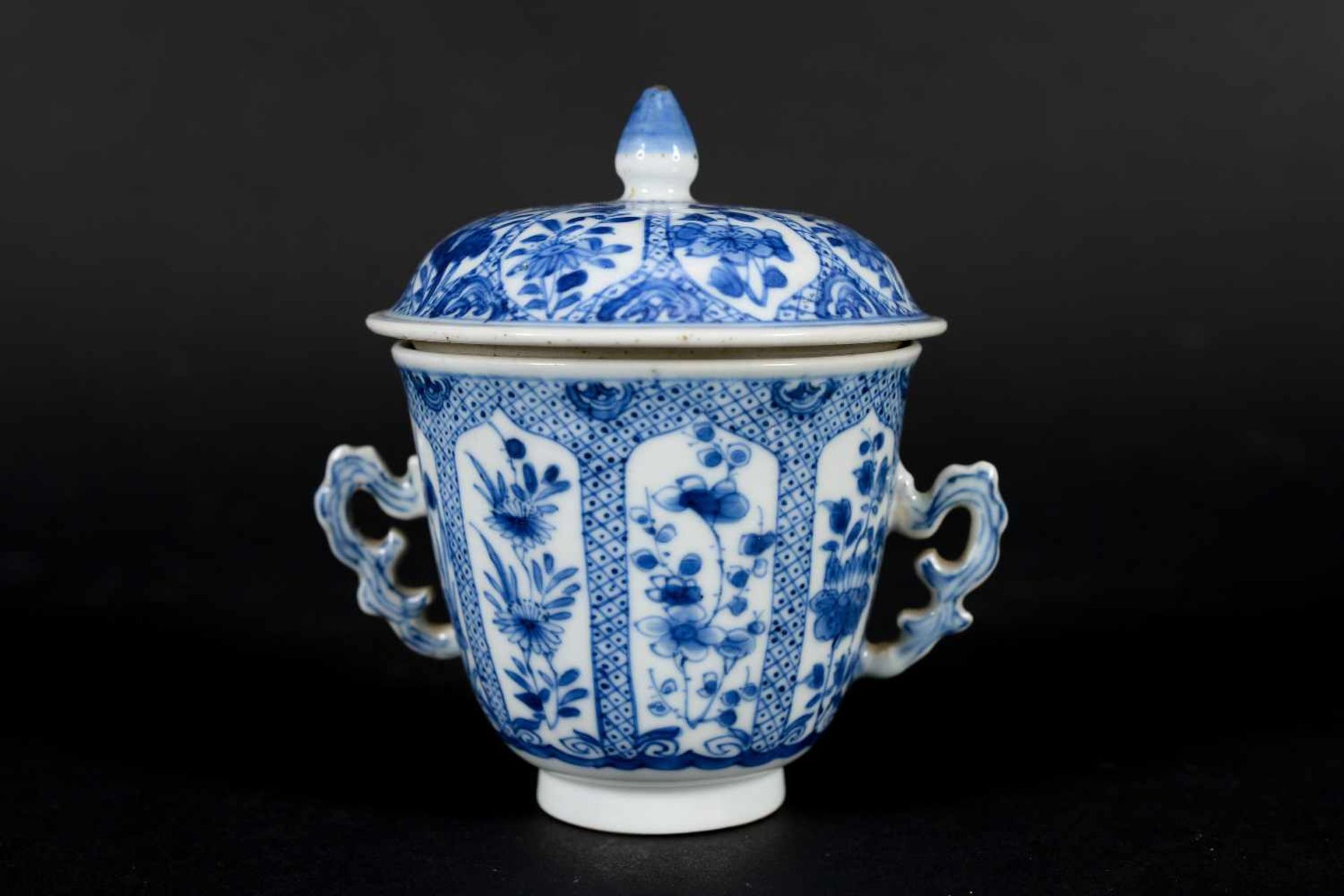A blue and white porcelain lidded cup with two handles on a deep saucer, decorated with flowers. - Image 5 of 9