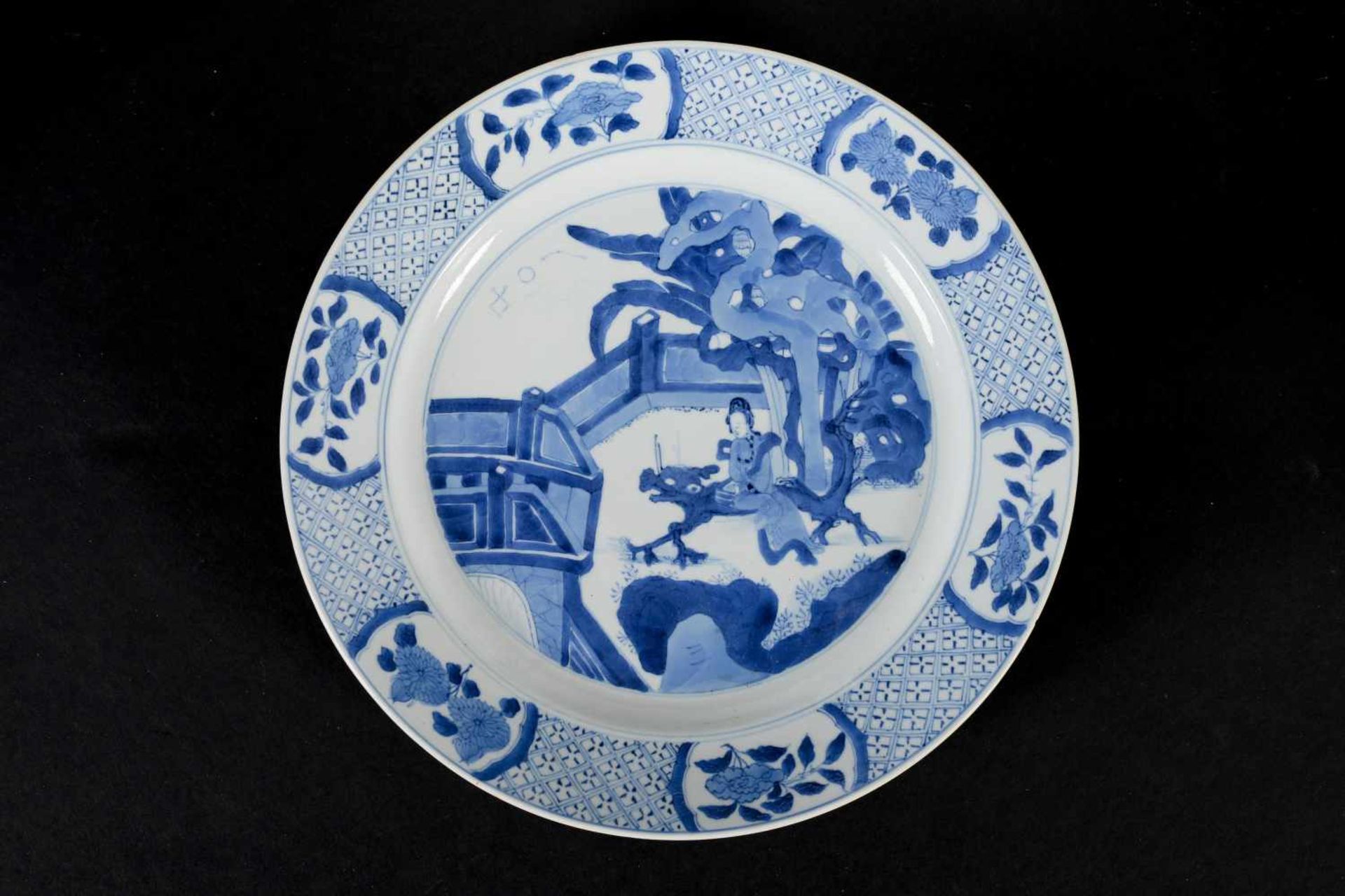 A blue and white porcelain dish, decorated with long Eliza on a bench in a garden. Marked with 6- - Image 3 of 3