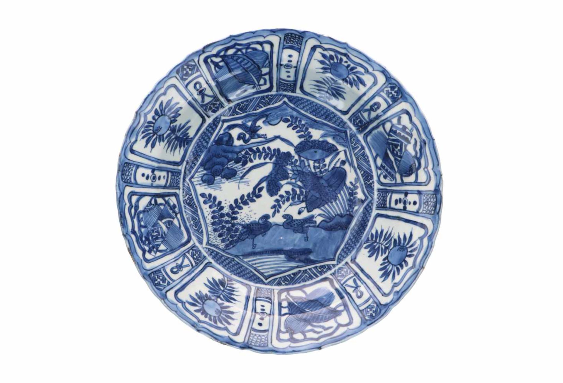 A blue and white porcelain charger, decorated with water birds and reserves depicting peaches and