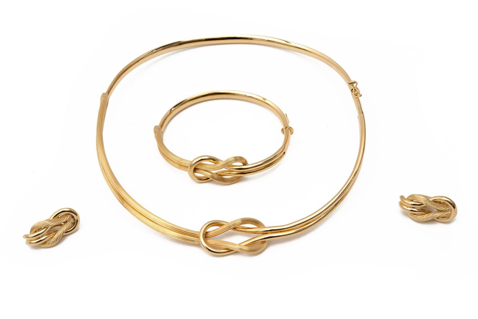 An infinity knot 18-kt golden choker with matching bracelet and a pair of ear clips. Total weight ap