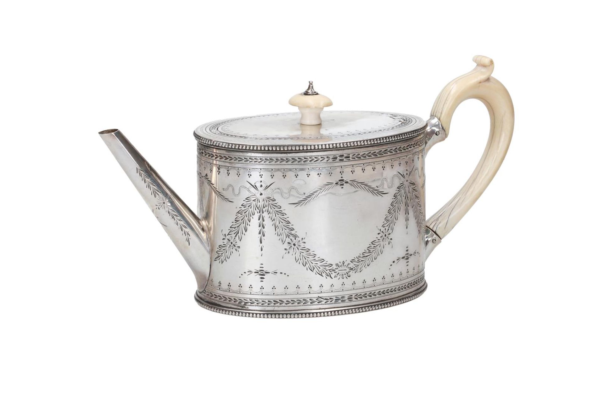 An oval first grade silver teapot with ivory handle and knob. With engraving of garlands. England, 1