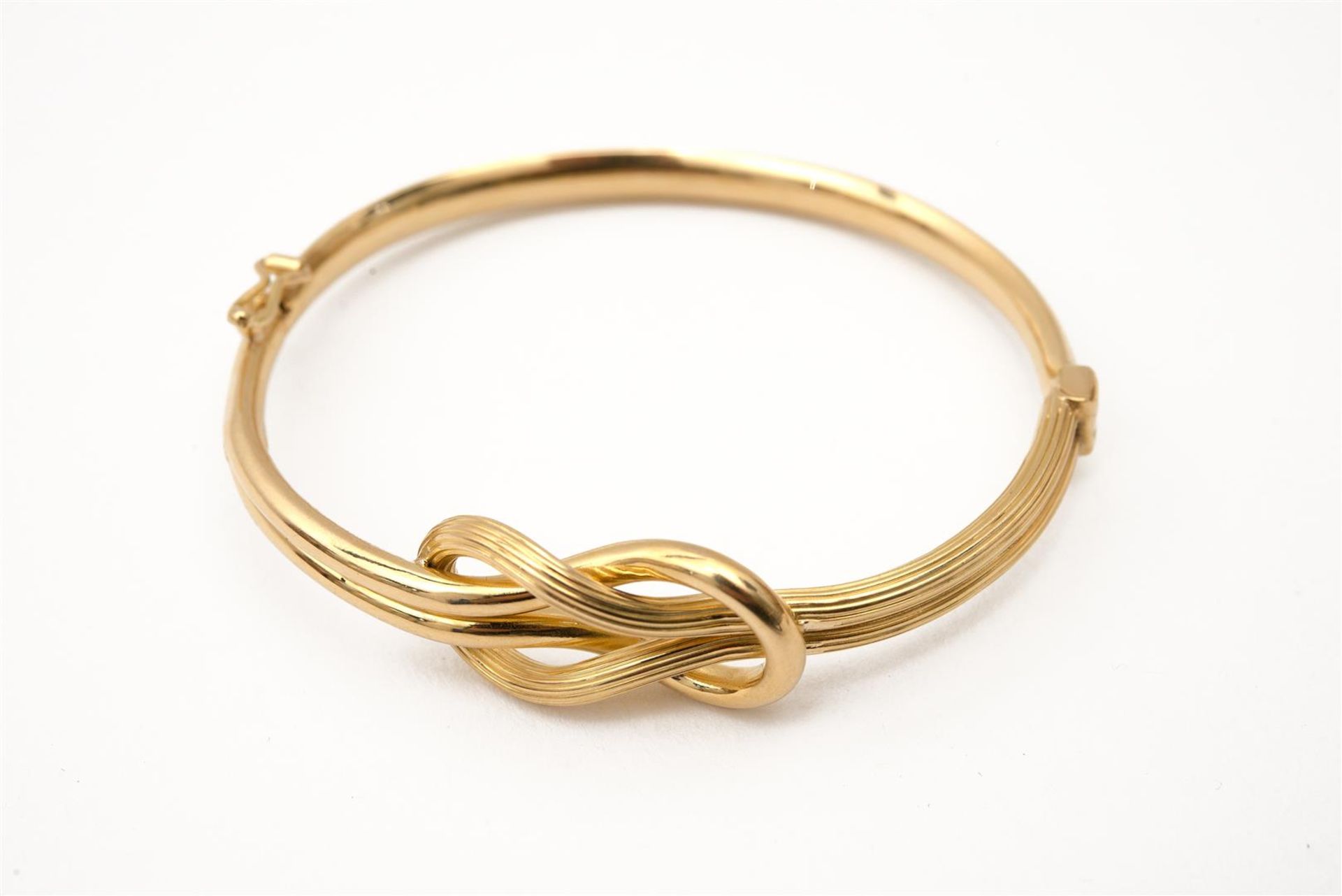 An infinity knot 18-kt golden choker with matching bracelet and a pair of ear clips. Total weight ap - Image 3 of 4