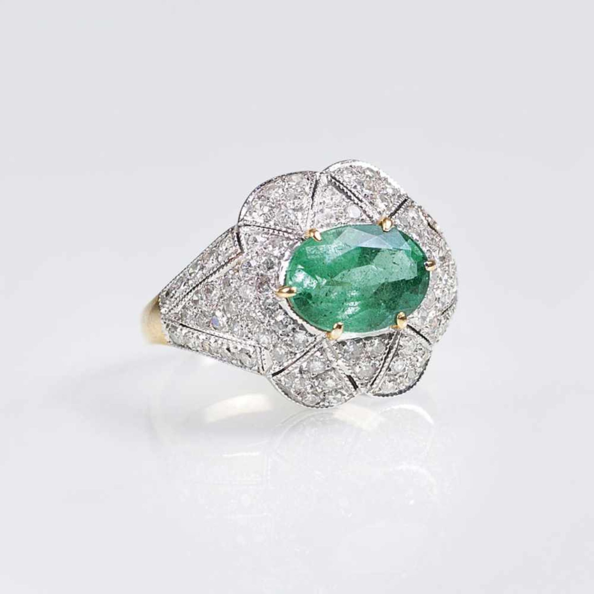 An Emerald Diamond Ring18 ct. yellow gold with white gold, marked. In front one emerald in oval