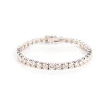 A DIAMOND TENNIS BRACELET Claw-set with thirty-fve round brilliant-cut diamonds weighing