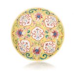 A CHINESE FAMILLE ROSE YELLOW GROUND ‘LOTUS AND MUSICAL STONE’ DISH, LATE REPUBLIC PERIOD, 1912 –