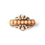 A CORAL AND SEED PEARL BROOCH Of symmetrical design, centred with a row of coral cabochons between