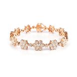 A DIAMOND BRACELET Designed as a series of fower head motifs, graduated in size, claw-set throughout