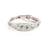 AN EMERALD AND DIAMOND BRACELET Of Art Deco design, the tapered band embellished with old-cut