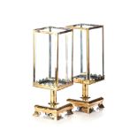 A PAIR OF BRASS CANDLE HOLDERS, 19TH CENTURY Each four glass hood on a turned support, on a square