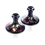 A PAIR OF MOORCROFT 'ANEMONE' PATTERN CANDLE HOLDERS The tube-lined flowers against a shaded deep