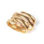 A GOLD SNAKE BANGLE Designed as a fexible stretch spiral, the eyes highlighted with circular mixed-