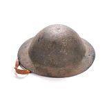 A WWI STEEL TOMMY HELMET With original liner and chin strap, retaining most of its stippled finish