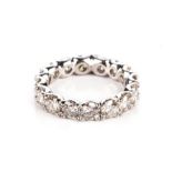 A DIAMOND ETERNITY RING Claw-set with sixteen round brilliant-cut diamonds weighing approximately