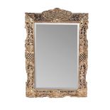 A VICTORIAN BRASS MIRROR The bevelled brass plate within a conforming brass frame, pierced and