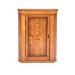 A GEORGE III HANGING CORNER CUPBOARD The outswept cornice with canted corners above a plain