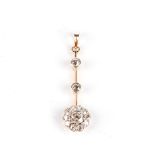 A DIAMOND PENDANT Designed as a knife-edge bar terminating in a flower-head cluster, embellished