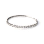 A DIAMOND BANGLE Claw-set to the centre with 23 round brilliant-cut diamonds, with a combined weight