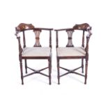 A PAIR OF MAHOGANY EDWARDIAN CORNER ARMCHAIRS With satinwood marquetry on back support, atop two