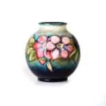 A MOORCROFT 'CLEMATIS' PATTERN VASE Of circular form with green ground, painted initials,