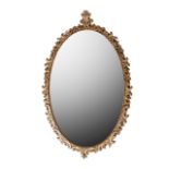 AN OVAL GILTWOOD MIRROR, 20TH CENTURY A foliage decorated frame surmounted by a carved leaf detailed