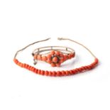 A CORAL AND SEED PEARL BANGLE Floral design to the centre, coral beaded sides 65mm diameter, in
