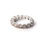 A FULL DIAMOND ETERNITY RING Claw-set with 15 light brown-champagne coloured diamonds, with a