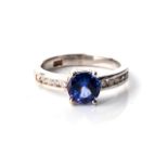 A TANZANITE AND DIAMOND RING Claw-set to the centre with a round brilliant-cut tanzanite, weighing