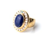 A LAPIS LAZULI AND DIAMOND RING Bezel-set to the centre with an oval lapis lazuli 15mm long and
