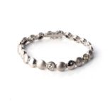 A DIAMOND TENNIS BRACELET Designed as a series of circles, matte and shiny combination, set with 5