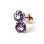 A PAIR OF TANZANITE EARRINGS Claw-set to the centre with a pair of round, brilliant-cut