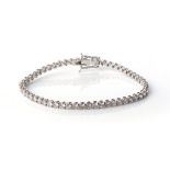 A DIAMOND TENNIS BRACELET Claw-set with round, brilliant-cut diamonds, weighing approximately 1,