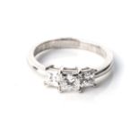 A TRILOGY DIAMOND RING Claw-set to the centre with a princess-cut diamond, weighing 0,55cts,