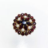 A PEARL AND GARNET BROOCH claw set to the centre with a 7mm round faceted garnet, set with 6