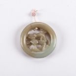 A CHINESE CELADON JADE 'QILIN' PENDANT Circular, carved to the centre with a horned qilin trotting