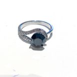 A DIAMOND RING claw set to the centre with a round brilliant cut black diamond weighing