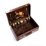 A GENTLEMAN'S TRAVEL CASE The hinged lockable top enclosing a compartment, with leather carrying