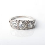 A DIAMOND TRILOGY RING bezel set to the centre with 3 old cut diamonds with a combined weight of