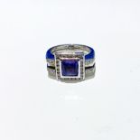 A TANZANITE AND DIAMOND RING bezel set to the centre with a princess cut tanzanite weighing 1,97