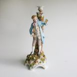 A CAPIDOMONTE-STYLE CANDLE HOLDER Depicting a gentleman in a blue jacket, standing in front of a