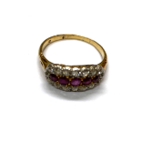 A RUBY AND DIAMOND RING Centred with a graduated line of five circular mixed-cut rubies surrounded
