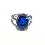 A SAPPHIRE AND DIAMOND RING claw set to the centre with an oval brilliant cut sapphire weighing