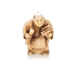 A JAPANESE IVORY NETSUKE OF AN ARTISAN, MEIJI PERIOD, 1868 - 1912 NOT SUITABLE FOR EXPORTThe