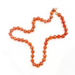 A STRAND OF FACETED AMBER BEADS 44cm in length, each bead approximately 5.5mm, with 9ct gold clasp