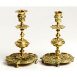 A NEAR PAIR OF BRASS CANDLESTICKS