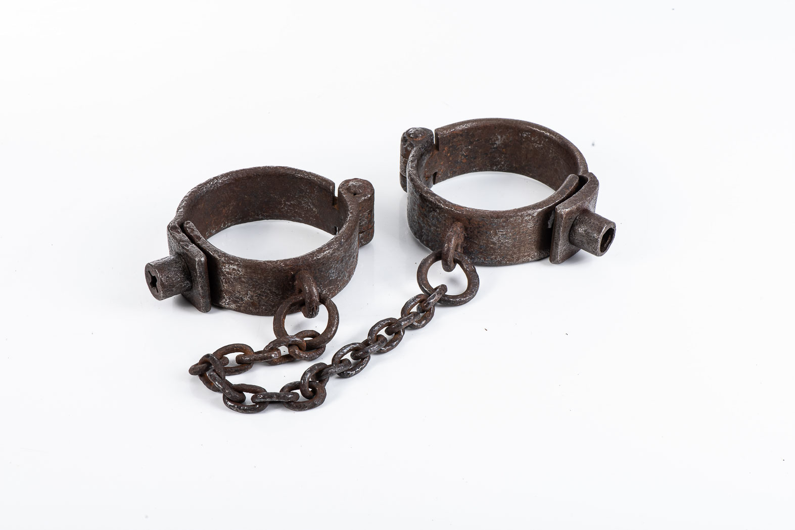 ANTIQUE IRON LEG IRONS Chain gang-style hand forged iron cuffs with a twisted hinge point