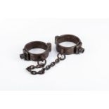 ANTIQUE IRON LEG IRONS Chain gang-style hand forged iron cuffs with a twisted hinge point